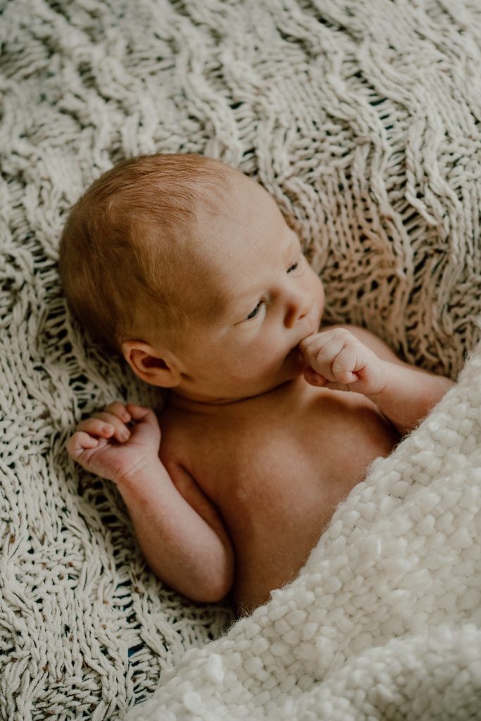Nouveau-né photographié en séance lifestyle, image douce et intemporelle réalisée par une photographe spécialisée en photographie familiale au Québec.