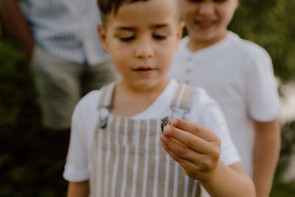 Détail d’un enfant tenant un petit objet dans ses mains lors d’une séance lifestyle familiale, photographie naturelle et douce réalisée par une photographe lifestyle au Québec.