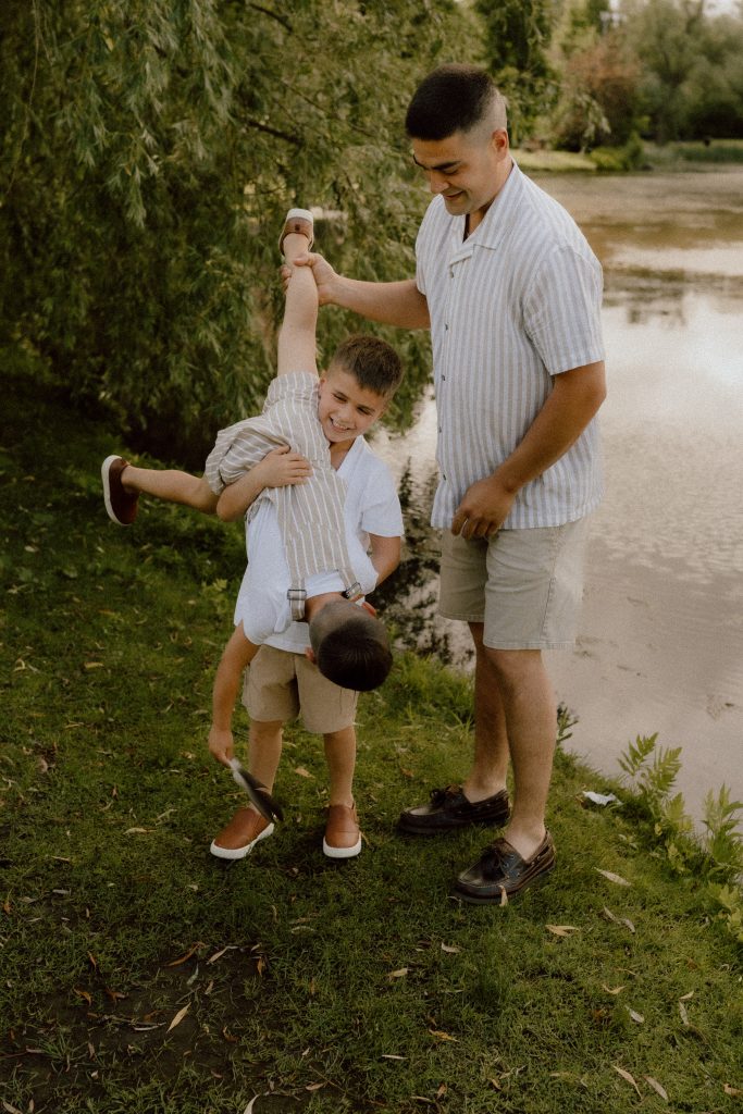 Papa jouant avec son enfant au bord de l’eau, scène de vie spontanée captée en photographie lifestyle familiale par une photographe professionnelle au Québec.
