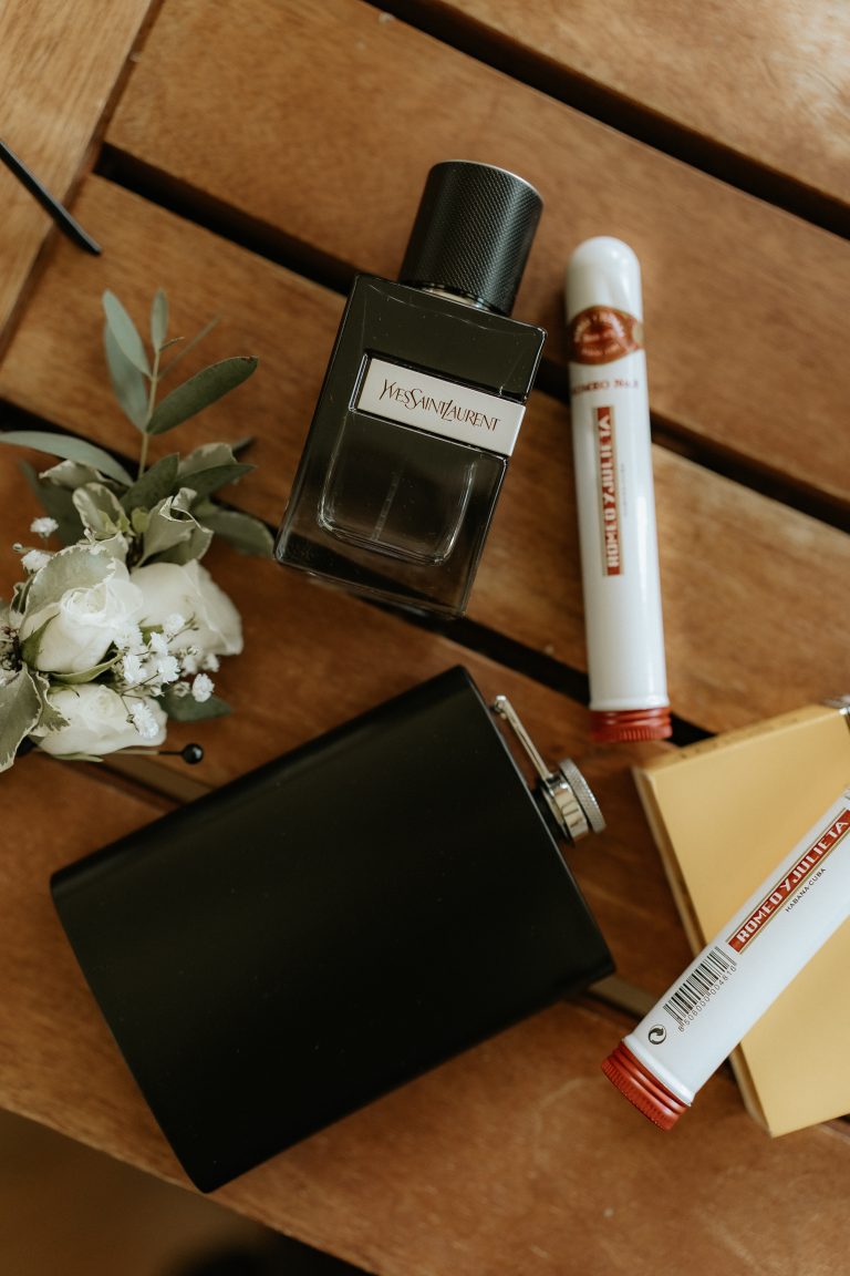 Photo d'accessoires masculins lors des préparatifs d'un mariage. Parfum, Cigare, fleurs.