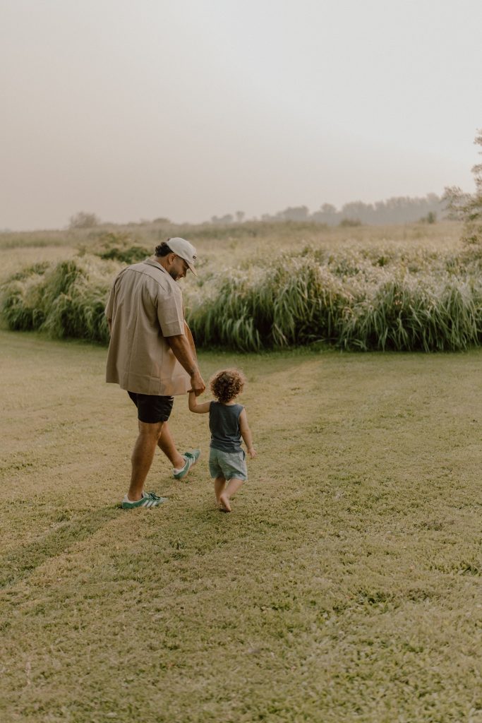 Parent jouant avec son enfant en plein air lors d’une séance lifestyle familiale, moment spontané capté par une photographe lifestyle spécialisée en famille au Québec.