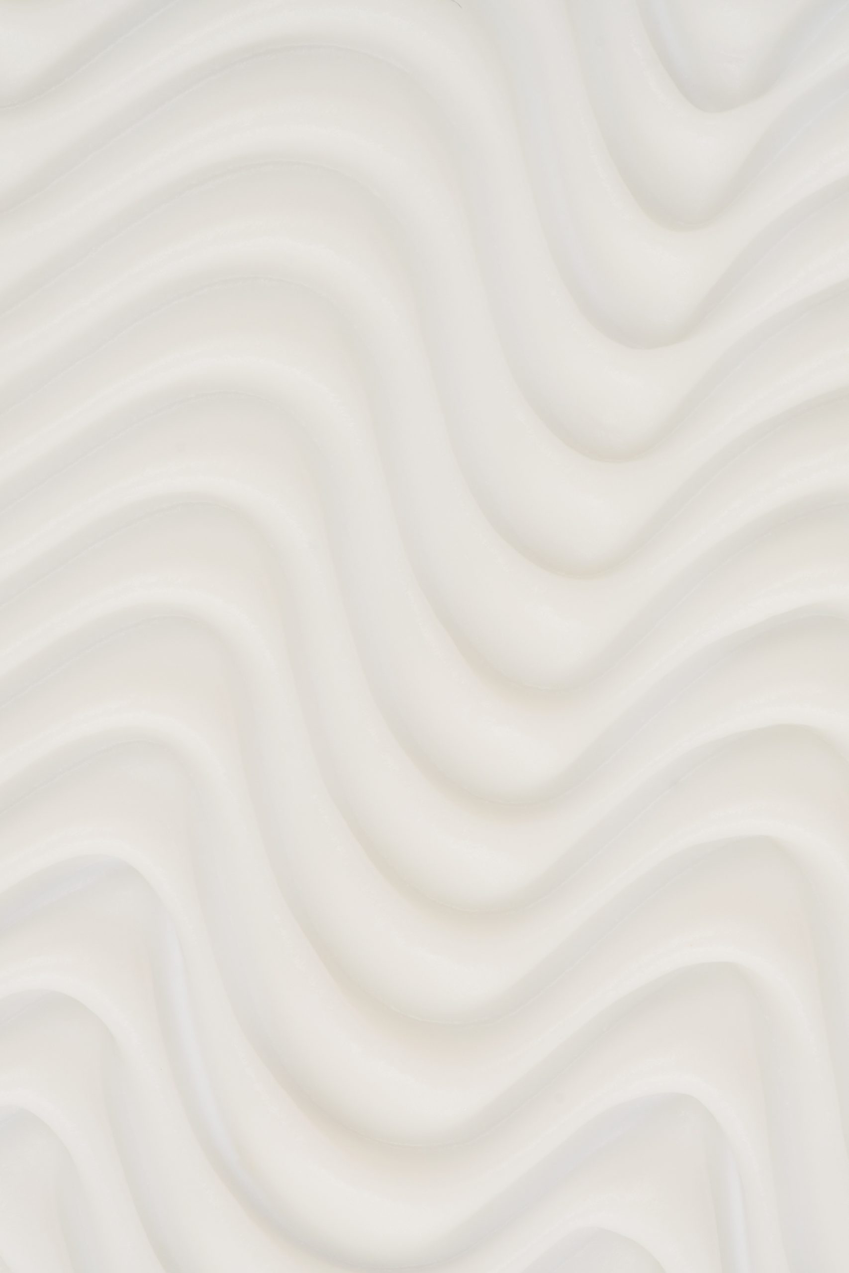 Fond texturé blanc aux formes ondulées et organiques créant une ambiance douce, épurée et moderne. Photographie de création de contenu idéale pour illustrer l’univers du bien-être, de la beauté et des soins personnels.