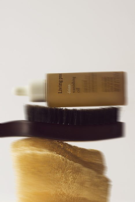 Photographie artistique de produit beauté avec effet de mouvement, flacon de soin et brosse en suspension, composition créative et esthétique éditoriale, photo produit réalisée par une photographe commerciale au Québec.