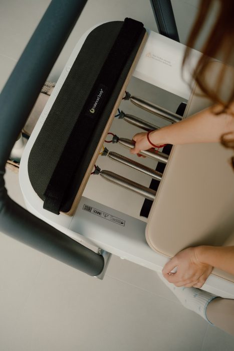 Photo professionnelle réalisée par une photographe commerciale capturant les ressors de machine pilates en lumière naturelle, esthétique premium et épurée. (photographe commerciale Québec, contenu commercial, studio pilates, Montréal)